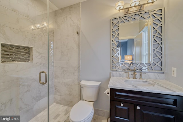 full bath with a shower stall, vanity, baseboards, and toilet