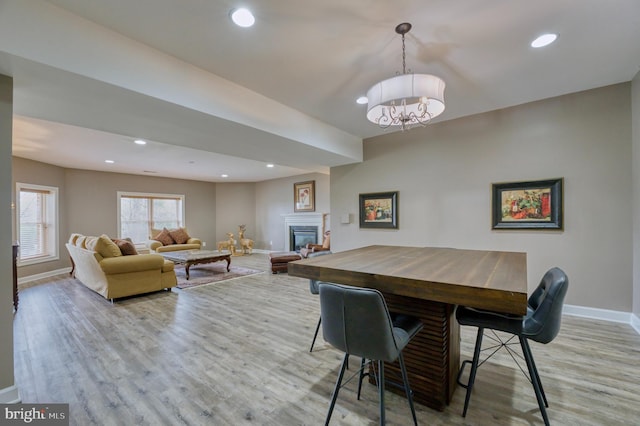 dining space featuring baseboards, recessed lighting, a notable chandelier, and light wood-style floors