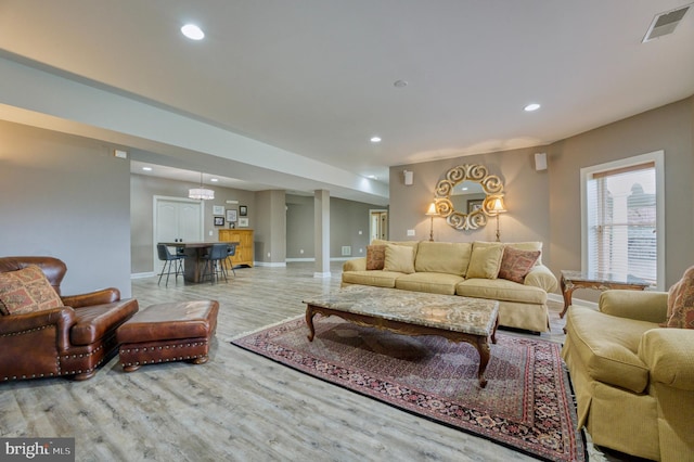 living area with recessed lighting, visible vents, baseboards, and wood finished floors