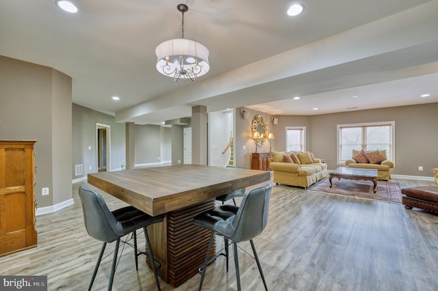 dining area featuring baseboards, a chandelier, recessed lighting, stairs, and light wood finished floors