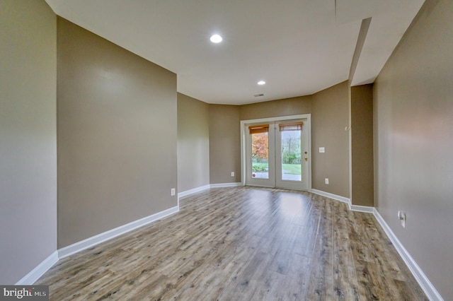 empty room featuring recessed lighting, baseboards, and wood finished floors