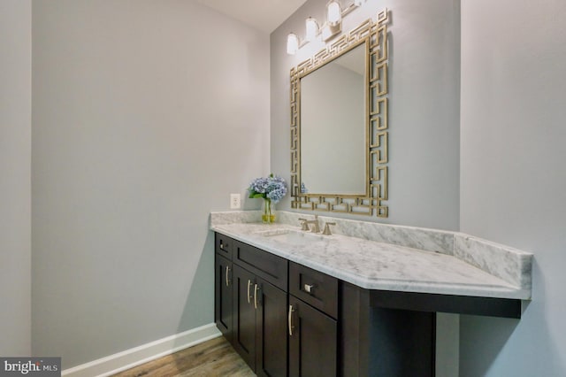 bathroom featuring wood finished floors, vanity, and baseboards