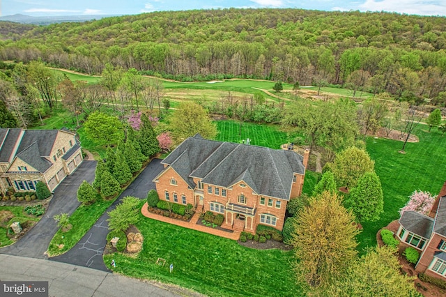bird's eye view with a wooded view
