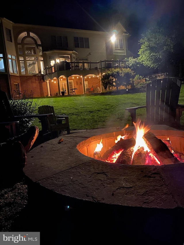 yard at twilight with a fire pit and a balcony