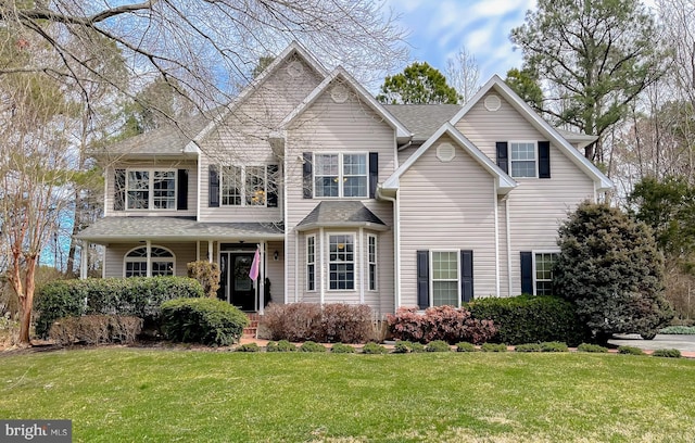 view of front of home with a shingled roof and a front lawn