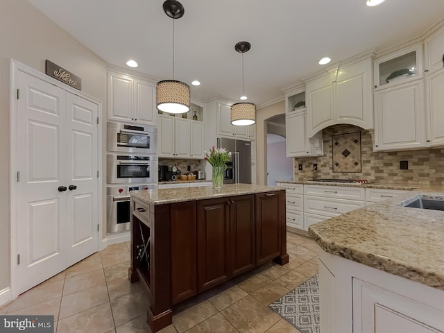 kitchen featuring white cabinets, glass insert cabinets, and stainless steel appliances