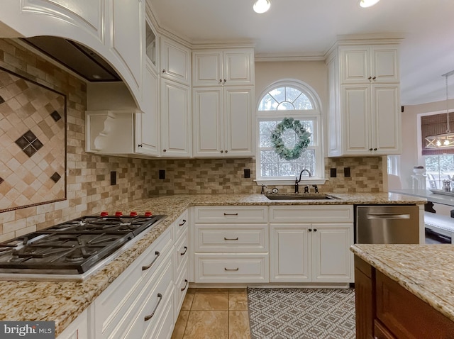 kitchen featuring light stone countertops, stainless steel appliances, a sink, decorative backsplash, and custom range hood