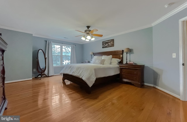 bedroom with baseboards, light wood-style flooring, and crown molding