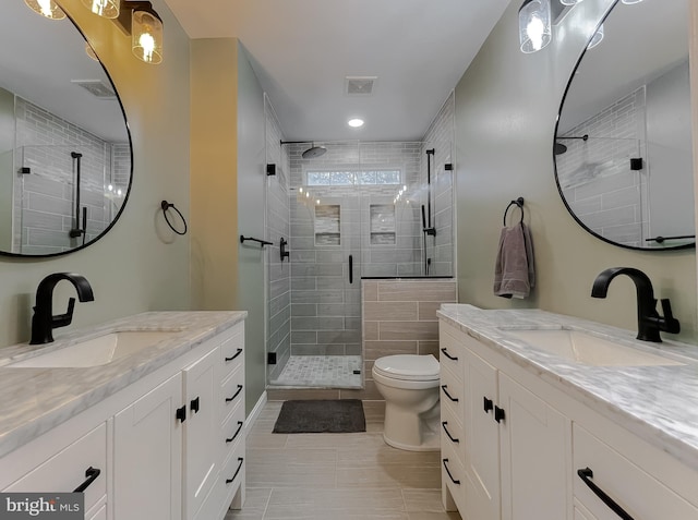 bathroom with a stall shower, visible vents, and a sink