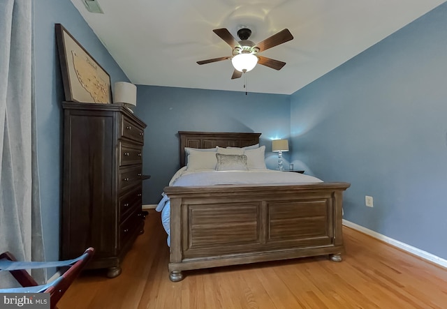 bedroom featuring a ceiling fan, baseboards, visible vents, and light wood finished floors