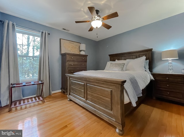 bedroom with a ceiling fan, visible vents, and light wood finished floors