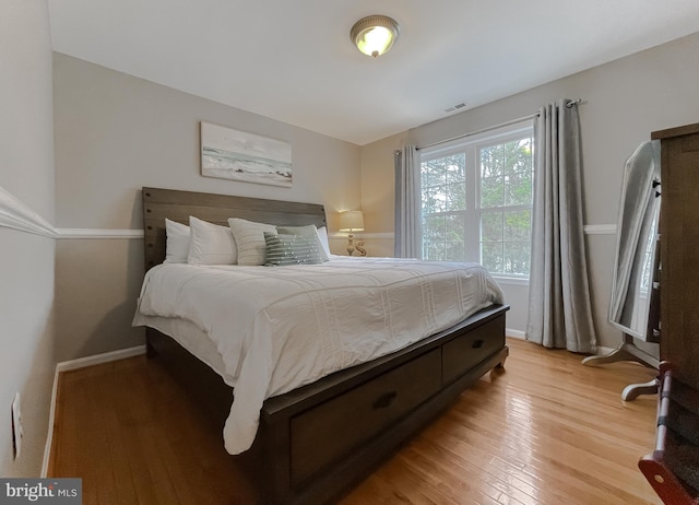 bedroom with light wood-type flooring, baseboards, and visible vents