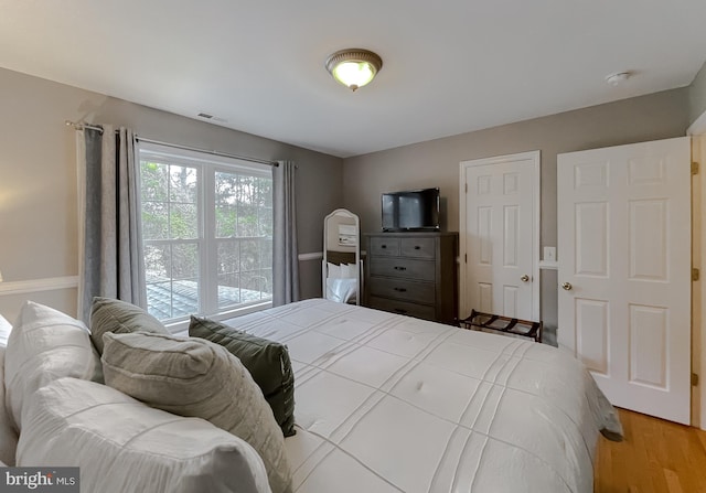 bedroom with visible vents and wood finished floors