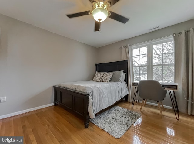 bedroom with baseboards, visible vents, ceiling fan, and light wood finished floors