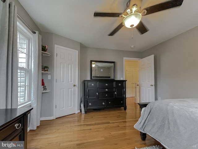 bedroom with light wood finished floors, baseboards, and a ceiling fan