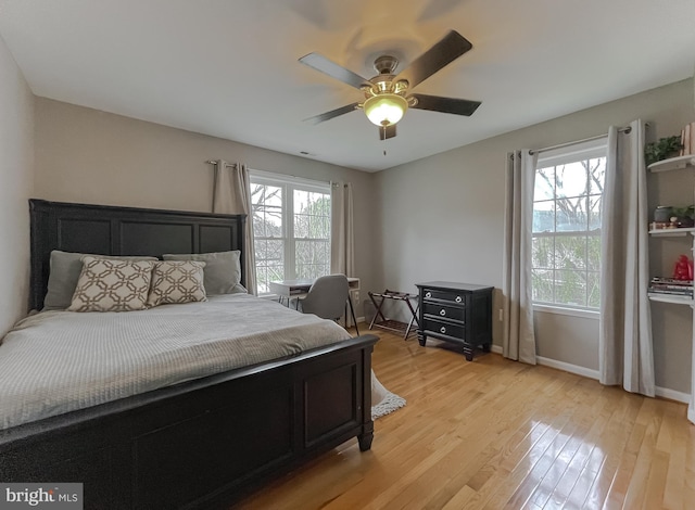 bedroom featuring light wood-type flooring, a ceiling fan, and baseboards