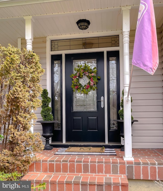 view of exterior entry featuring covered porch