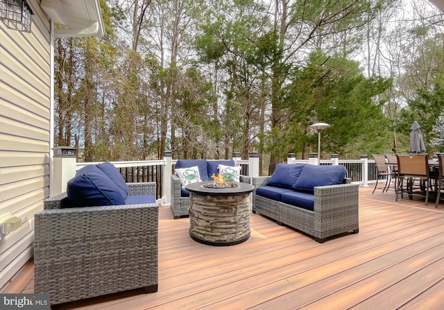 wooden terrace with outdoor dining area and an outdoor living space with a fire pit