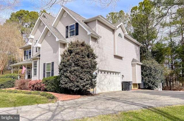 view of side of home featuring a garage and driveway