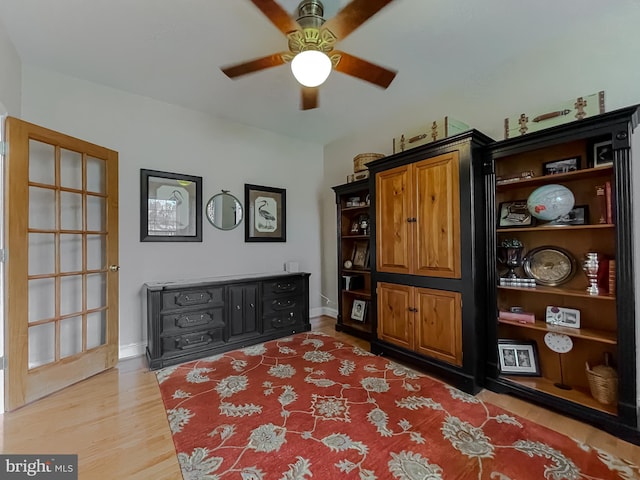 sitting room with ceiling fan, light wood-type flooring, and baseboards