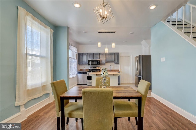 dining area featuring visible vents, baseboards, stairway, light wood-style floors, and recessed lighting