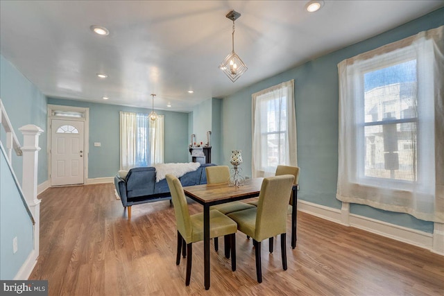 dining room with stairs, baseboards, wood finished floors, and recessed lighting