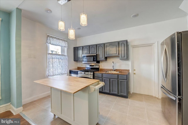 kitchen with light tile patterned floors, decorative light fixtures, stainless steel appliances, gray cabinetry, and a sink