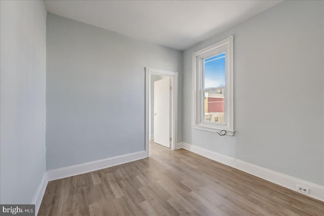 empty room featuring wood finished floors and baseboards