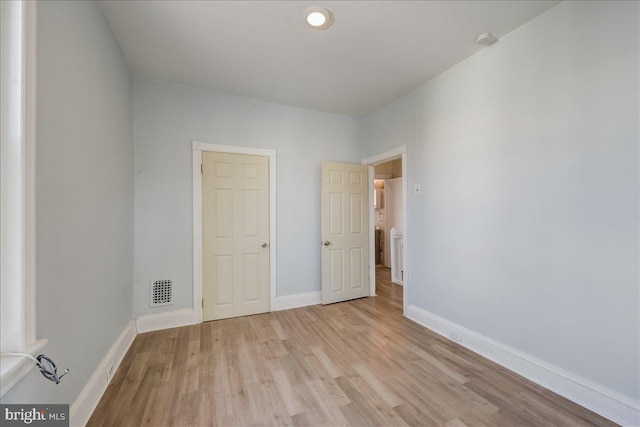 unfurnished bedroom featuring light wood-style floors, visible vents, and baseboards