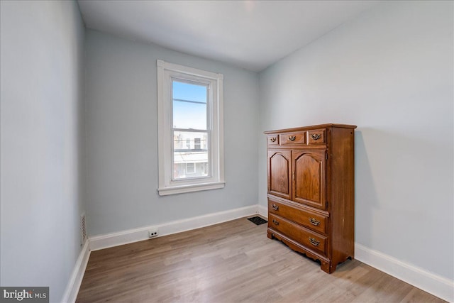 bedroom featuring light wood-style flooring, visible vents, and baseboards