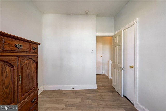 bedroom featuring light wood finished floors and baseboards