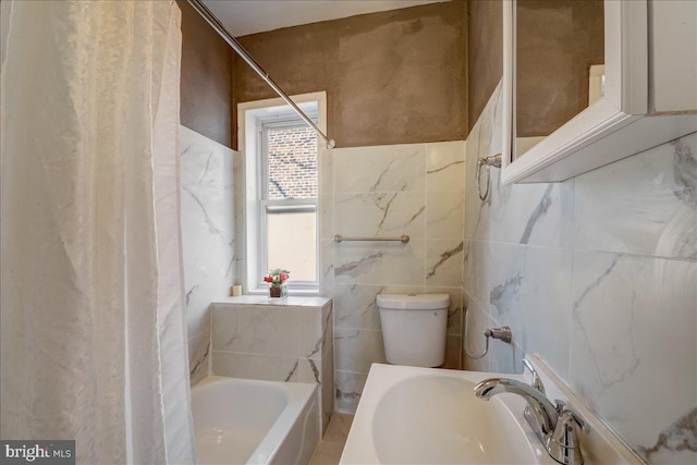 bathroom with shower / bath combo, a sink, and toilet