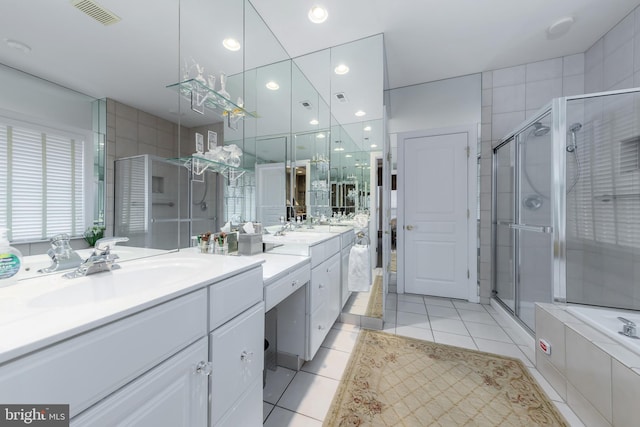 bathroom with a stall shower, tile patterned flooring, a sink, and visible vents