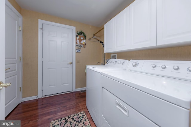 laundry area featuring dark wood-type flooring, washer and clothes dryer, cabinet space, and baseboards