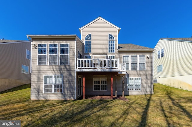 rear view of house featuring a yard and a deck