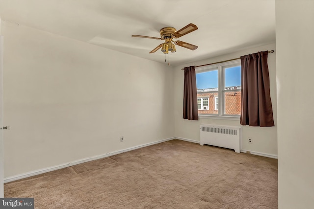 unfurnished room with ceiling fan, carpet floors, baseboards, and radiator