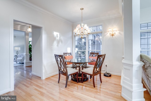 dining space with decorative columns, baseboards, ornamental molding, light wood-style floors, and a chandelier