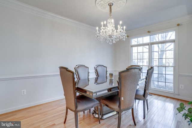 dining space featuring light wood-type flooring, a healthy amount of sunlight, crown molding, and baseboards