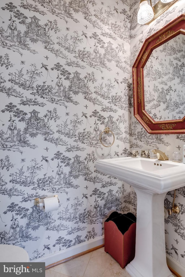 bathroom with tile patterned flooring, a sink, baseboards, and wallpapered walls