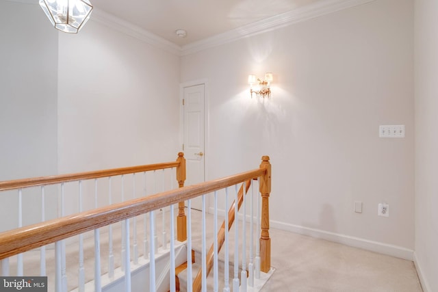 hall featuring baseboards, carpet floors, an upstairs landing, and crown molding