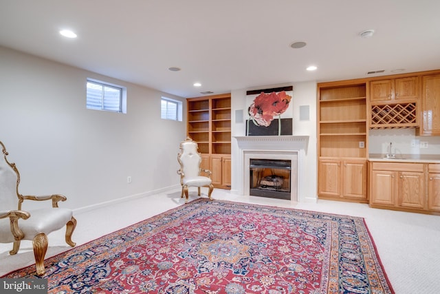 sitting room with light carpet, baseboards, wet bar, a fireplace, and recessed lighting