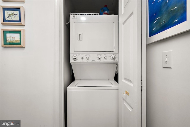 clothes washing area featuring laundry area and stacked washer and clothes dryer