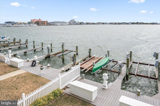 view of dock featuring a water view, boat lift, and fence