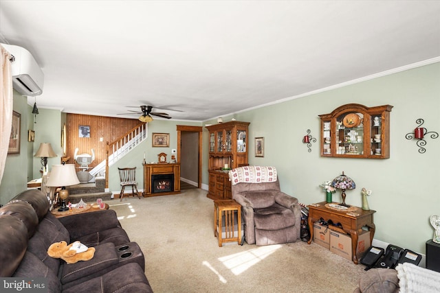 carpeted living room featuring ceiling fan, stairway, a lit fireplace, crown molding, and a wall mounted AC