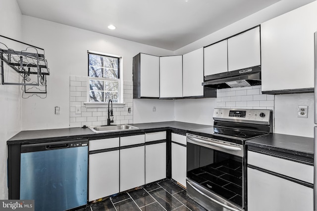 kitchen with dishwashing machine, under cabinet range hood, a sink, dark countertops, and stainless steel range with electric stovetop