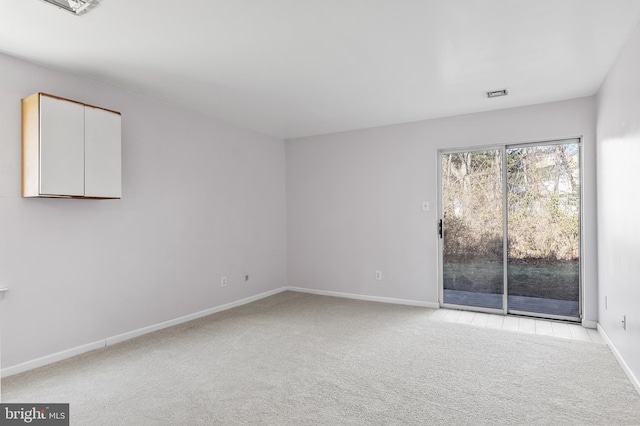 unfurnished room featuring carpet, visible vents, and baseboards