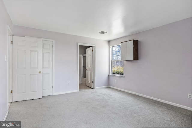 unfurnished bedroom with carpet, visible vents, and baseboards