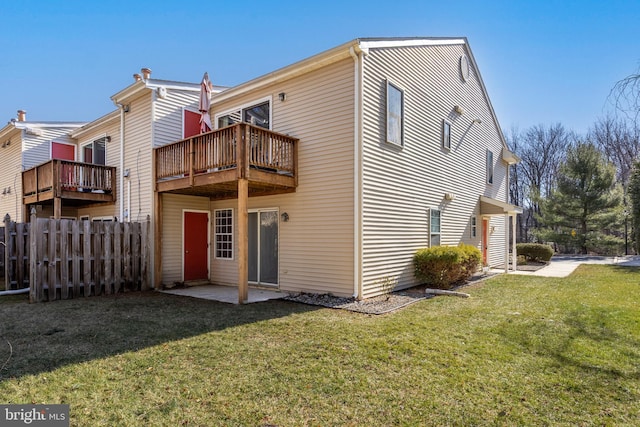 back of house featuring a yard, a patio, fence, and a balcony