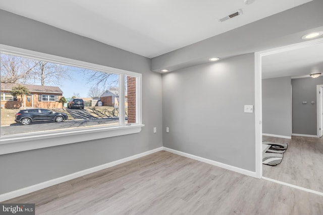 unfurnished room with recessed lighting, wood finished floors, visible vents, and baseboards