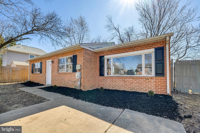 view of front facade with fence and brick siding